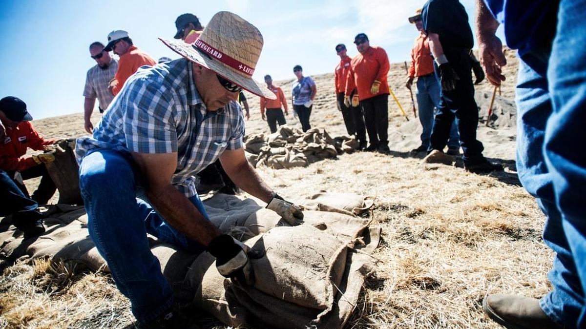 Rick Cantu, of Dos Palos, builds a sandbag wall during a flood fighting training course in October in preparation for El Niño in the Duck Slough area off of West Sandy Mush Road in Merced.