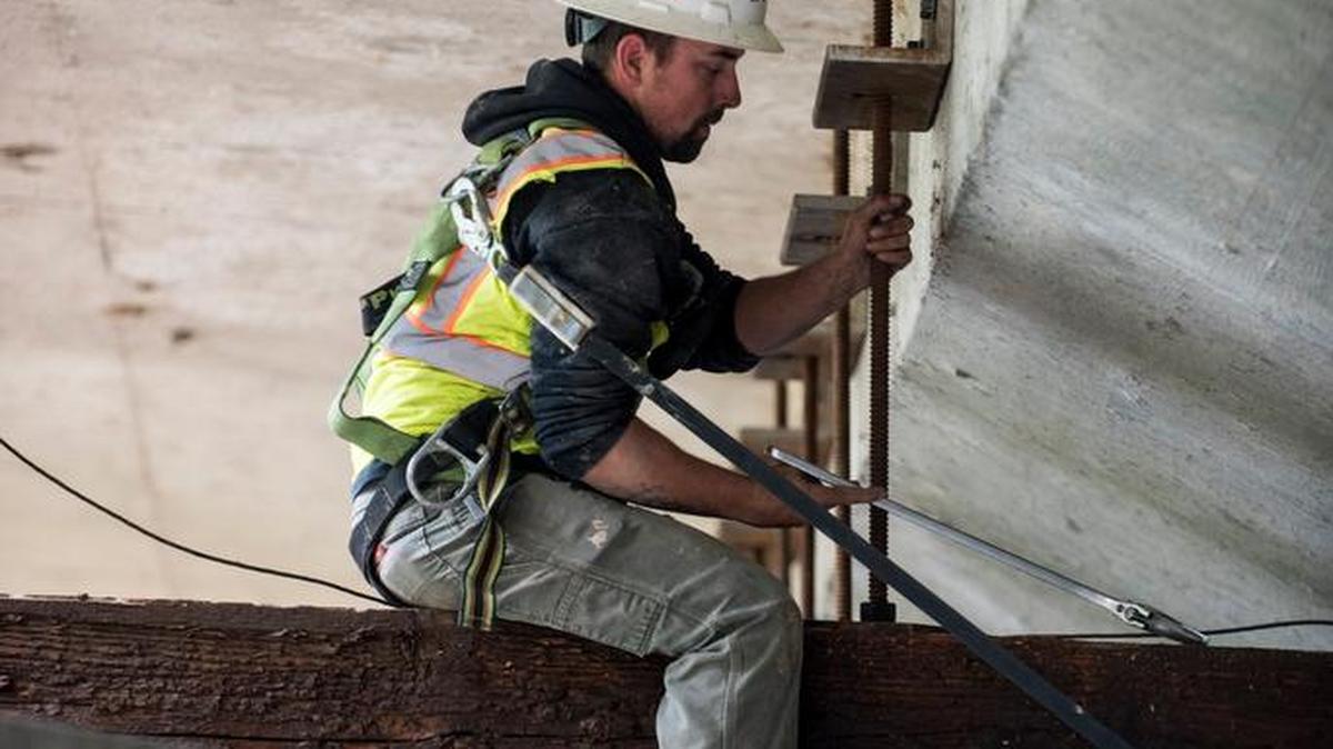 Steve Krisman, 26, of Ione, secures wooden beams to the M Street bridge as Viking Construction Co. workers prepare the bridge for rehabilitation work in Merced, Calif., on Tuesday, April 18, 2017. Work will be done to rehabilitate the bridge structure, the roadway and the creek channel.