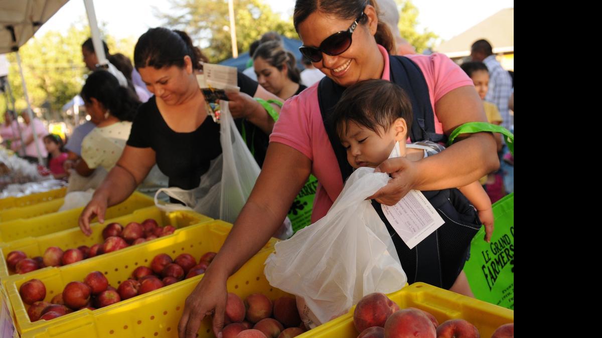 
Maria Velazco and Marta Guzman, with son Ravi Lopez, 7 months, all of Planada, shop during the first day of the Le Grand Farmers Market in 2012.
