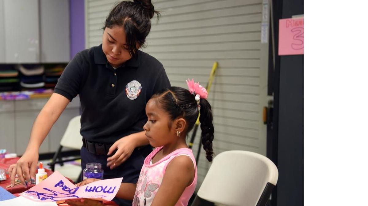 
Yessenia Martinez, left, helps 7-year-old Natalie Lopez apply glitter to an art project on Saturday during the Day for Kids event at the McCombs Youth Center in Merced.
