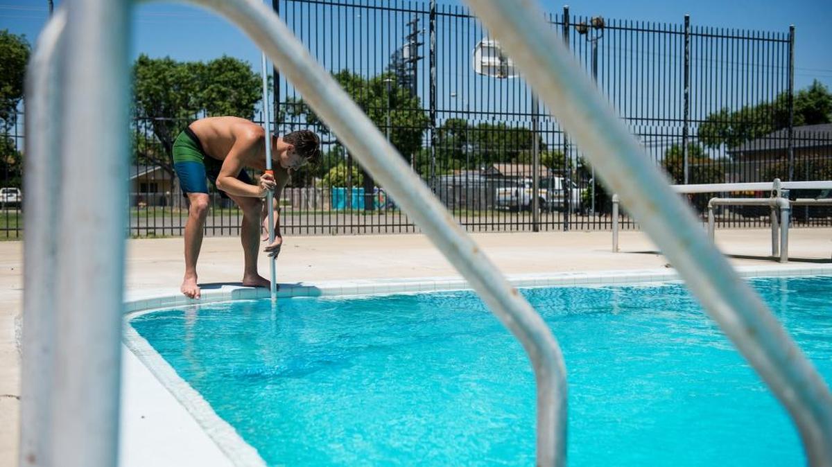 Lifeguard Paul Olano, 19, of Atwater, uses a vacuum and filtration system to clean dirt and debris from the pool at McNamara Park in Merced, Calif., on Thursday, May 25, 2017.