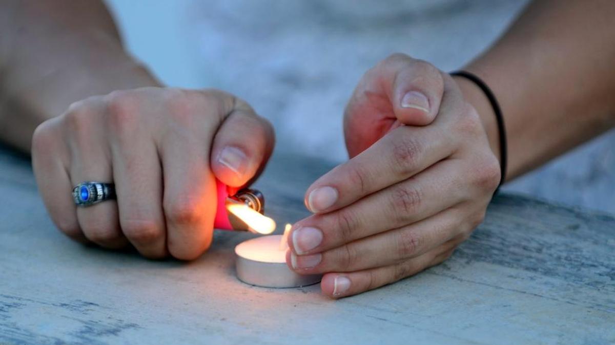A visitor lights a candle at a vigil June 25, 2015.