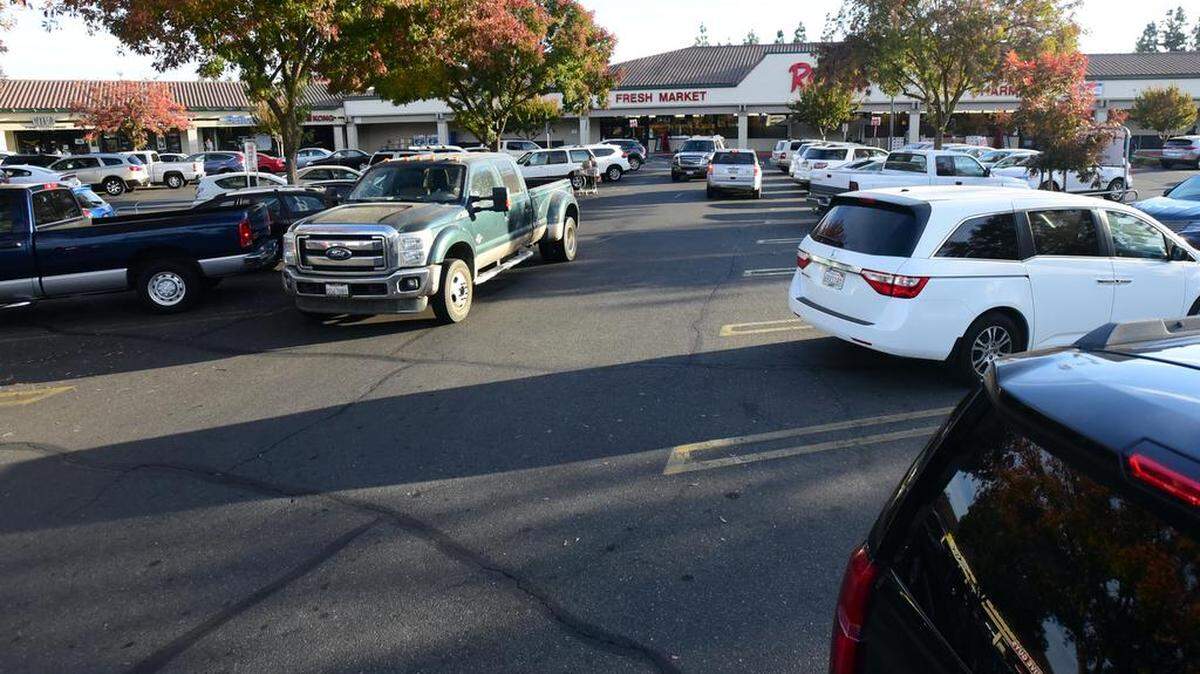 Drivers search for parking inside the Raley’s lot on Yosemite Avenue on Monday .