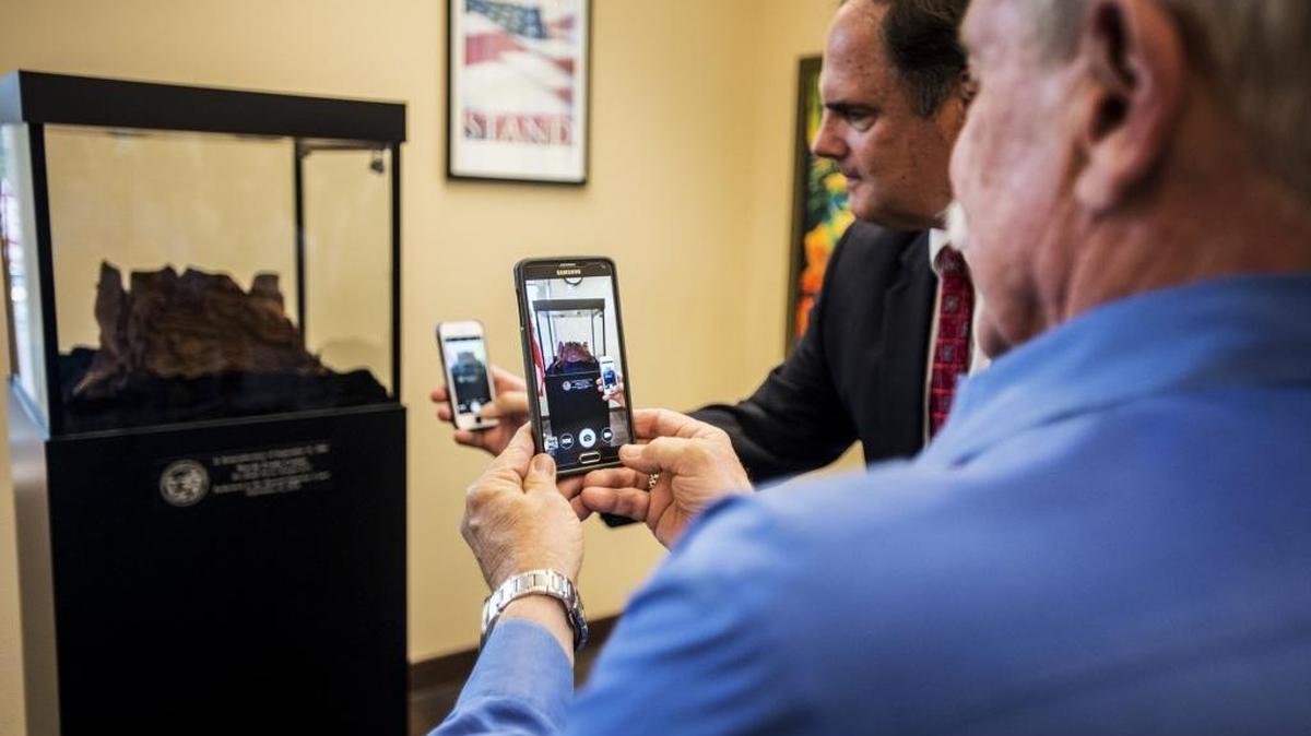 
Merced County District 2 Supervisor Hubert “Hub” Walsh, right, takes a photo of a World Trade Center artifact during a 9/11 memorial ceremony at the Merced County Superior Courthouse on Friday. According to the court’s executive officer, Linda Romero Soles, the process of acquiring the artifact has taken two years. “It’s amazing to have it here on the actual anniversary,” Soles said.
