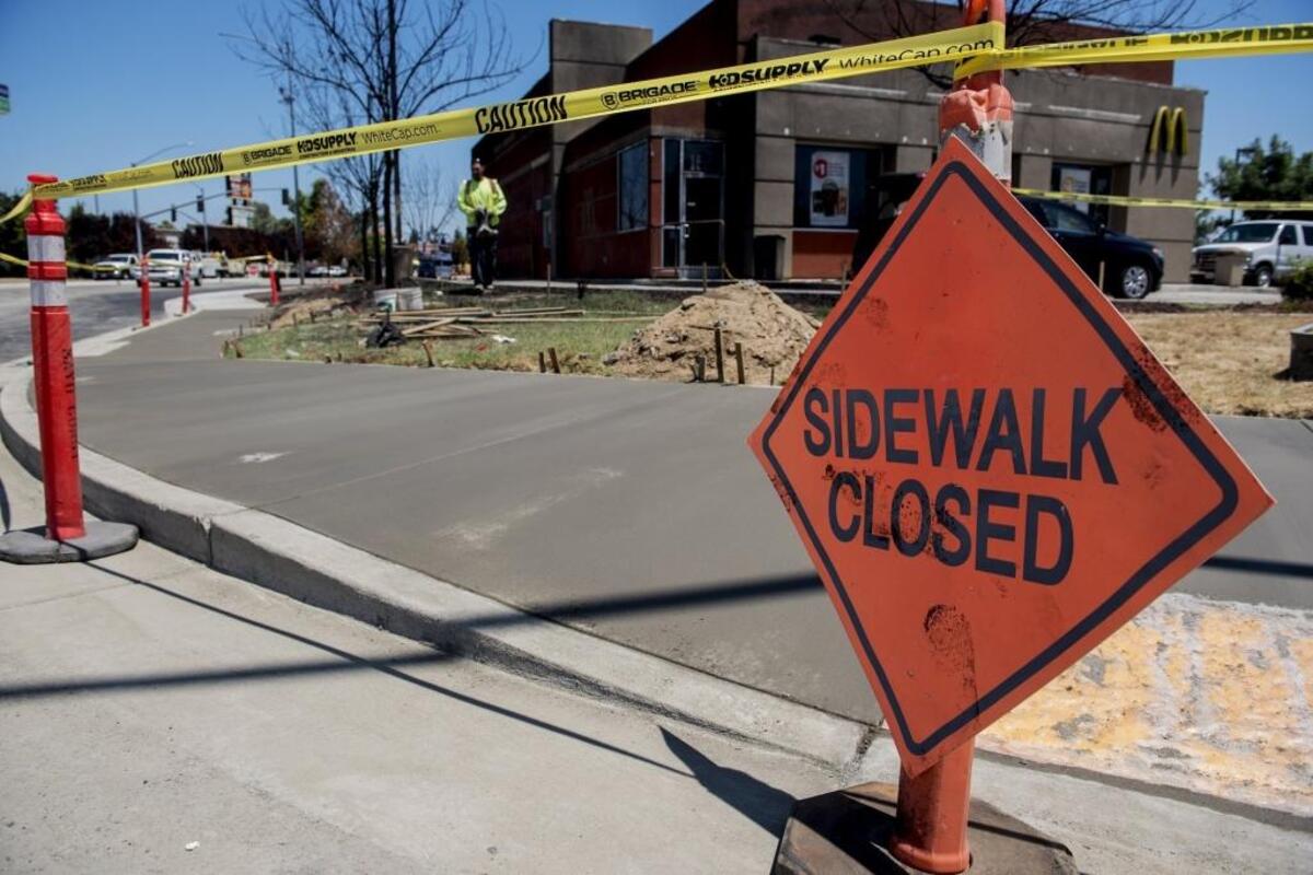 Crews finish pouring a new section of sidewalk near the McDonald’s at the intersection of Bell Drive and Bell Lane in Atwater, Calif., on Friday, June 23, 2017. The section of sidewalk is near the southbound Highway 99 exit 195 which reopened Friday after being closed for about a month following a fatal tanker truck crash and explosion.