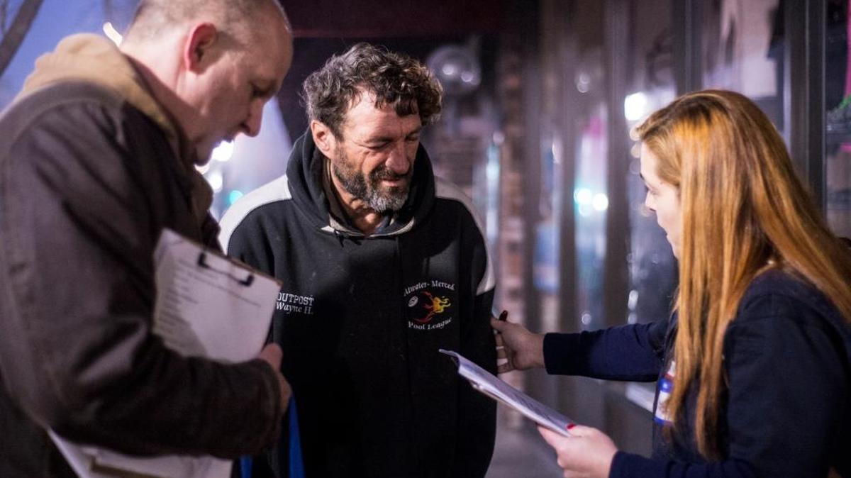Merced City Manager Steve Carrigan, left, and Riggs Ambulance Service Operations Supervisor Chantale Pakosz, right, speak with Kenny Pearson, 50, a homeless man along Main Street during the 2016 Merced City and County Continuum of Care Homeless Count in Merced, Calif., Jan. 28. Approximately 150 volunteers walked the city to speak with the homeless and offer them a quarter gallon bag containing snacks, socks and various hygiene products.