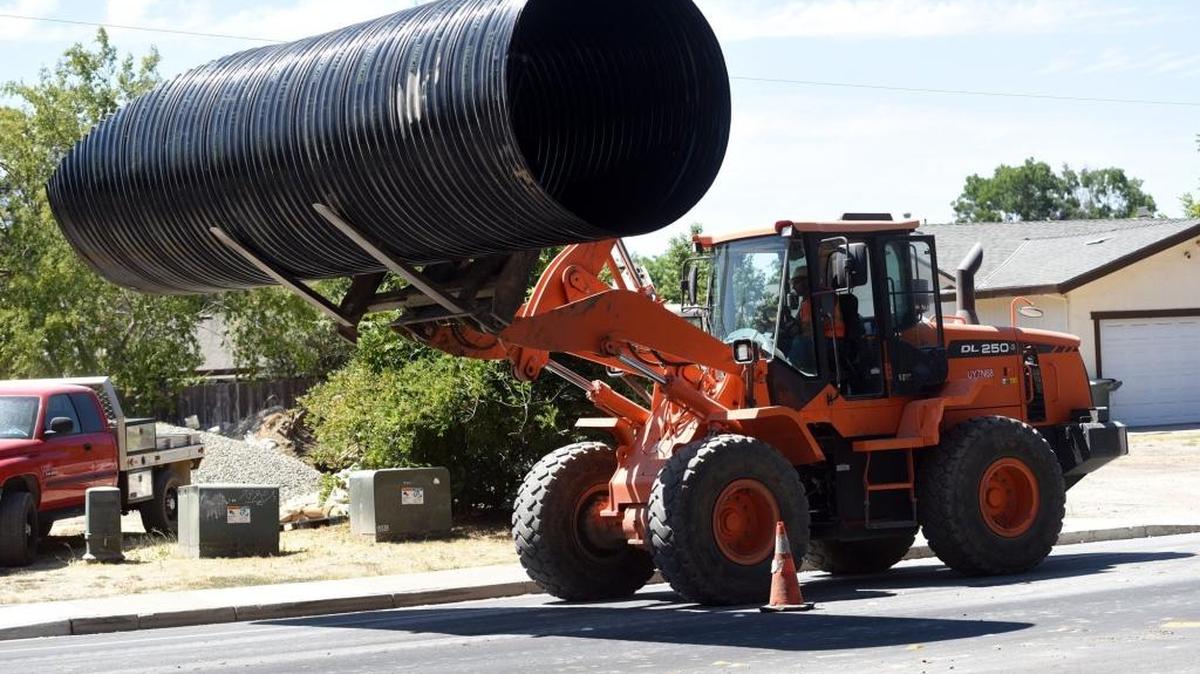 A crew works on a storm drain under M Street where Black Rascal Creek crosses under the roadway Thursday, Aug. 4, 2016. The bike path there is closed.