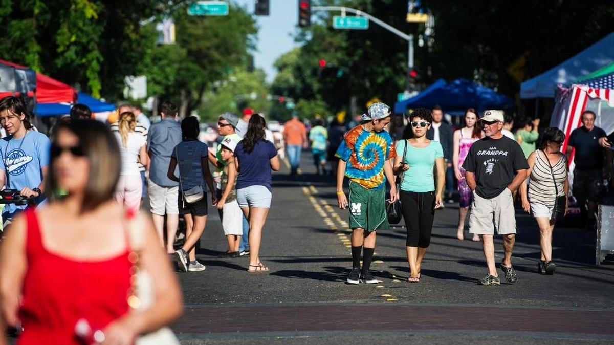 Fairgoers walk along West Main Street during the Merced Downtown Street Faire at West Main and Canal streets in Merced, Calif., on Thursday, June 23, 2016. The fair continues weekly through Sept. 1.