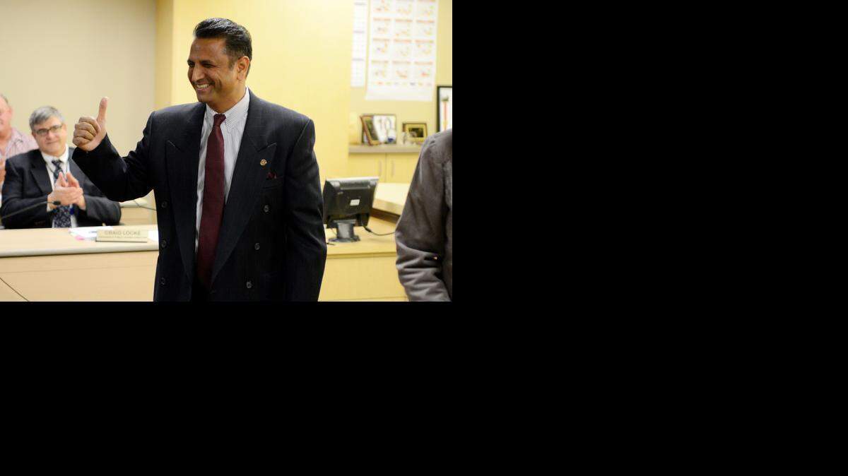 
Waseem Ahmed gestures to the crowd after taking the oath of office for Chowchilla City Council from City Clerk Nanci Lima on Tuesday at City Hall. 
