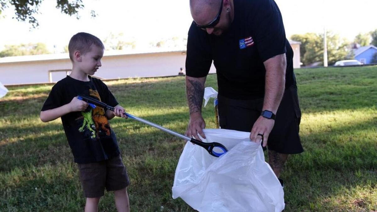 Anthony Pinheiro, 33, of Atwater and his 4-year-old son, Avery, pick up trash at Applegate Park in Merced on Wednesday, July 20, 2016. Fans of the mobile phone game “Pokémon Go” gathered this week to cleanup parks in Merced and Atwater.
