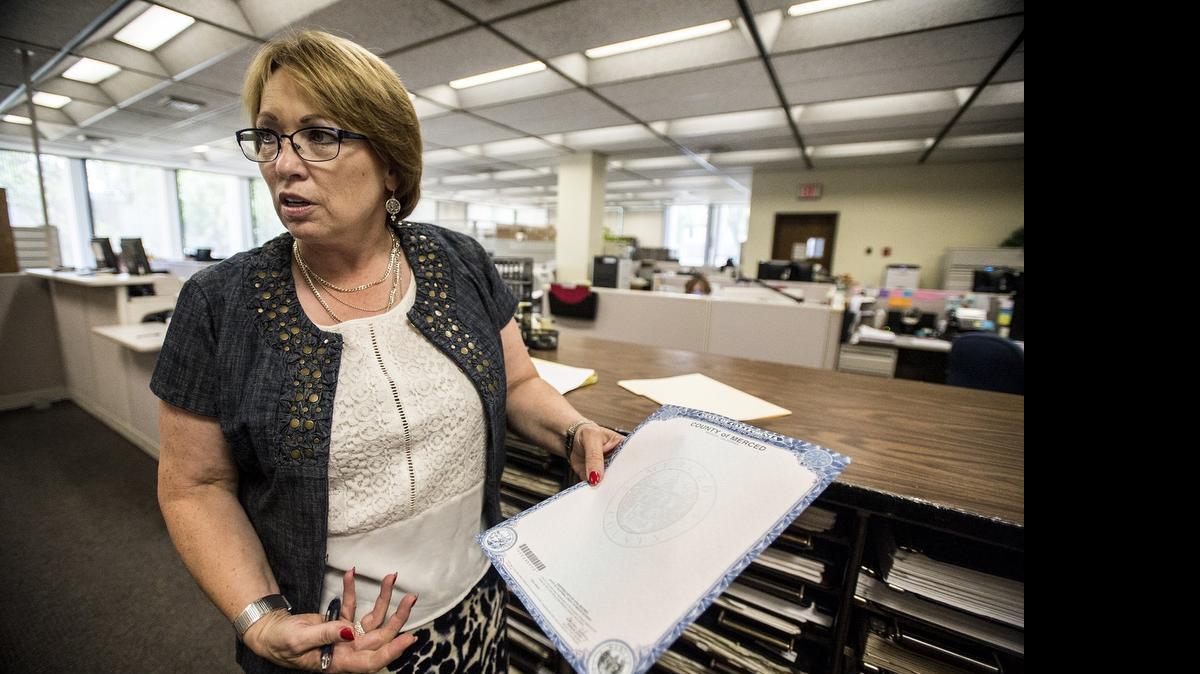 
Merced County Clerk Barbara Levey holds a piece of paper used for birth, death and marriage certificates. The county’s supplier of secure paper, NBN/Sekuworks LLC, located in Harrison, Ohio, has closed and will no longer supply the paper.
