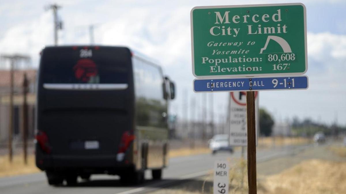 A bus passes a Merced sign on Highway 140 headed towards town on Thursday, Oct. 1, 2015.