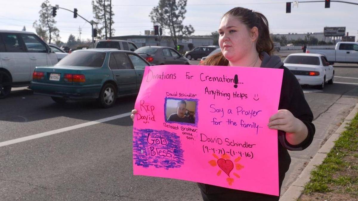 Melissa Schindler, 23, holds a sign seeking donations for funeral services for her uncle, David Schindler, who unexpectedly passed away at the age of 44 on Jan. 4, while standing at Olive Avenue and Highway 59 in Merced on Tuesday. Melissa and her sister, Jessica, 19, are trying to raise $800 to $1,500 for cremation services for their uncle. The death of their uncle has also left them with no money for living and housing expenses, and they’ve had a difficult time finding assistance from local agencies.
