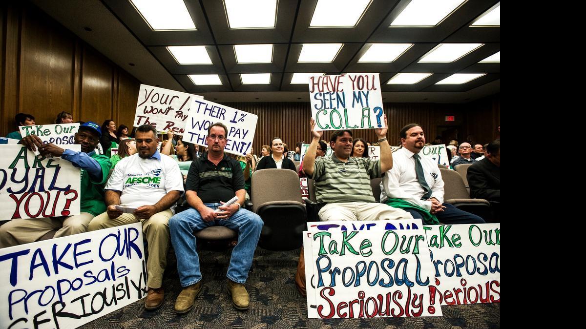 
Merced County employees display signs inside the Board of Supervisors meeting at the Merced County Building at 2222 M Street in Merced, Calif., Tuesday May 5, 2015. The employees gathered to voice their unhappiness over current contract negotiations with the county. Many county employees have not received a raise since 2009.
