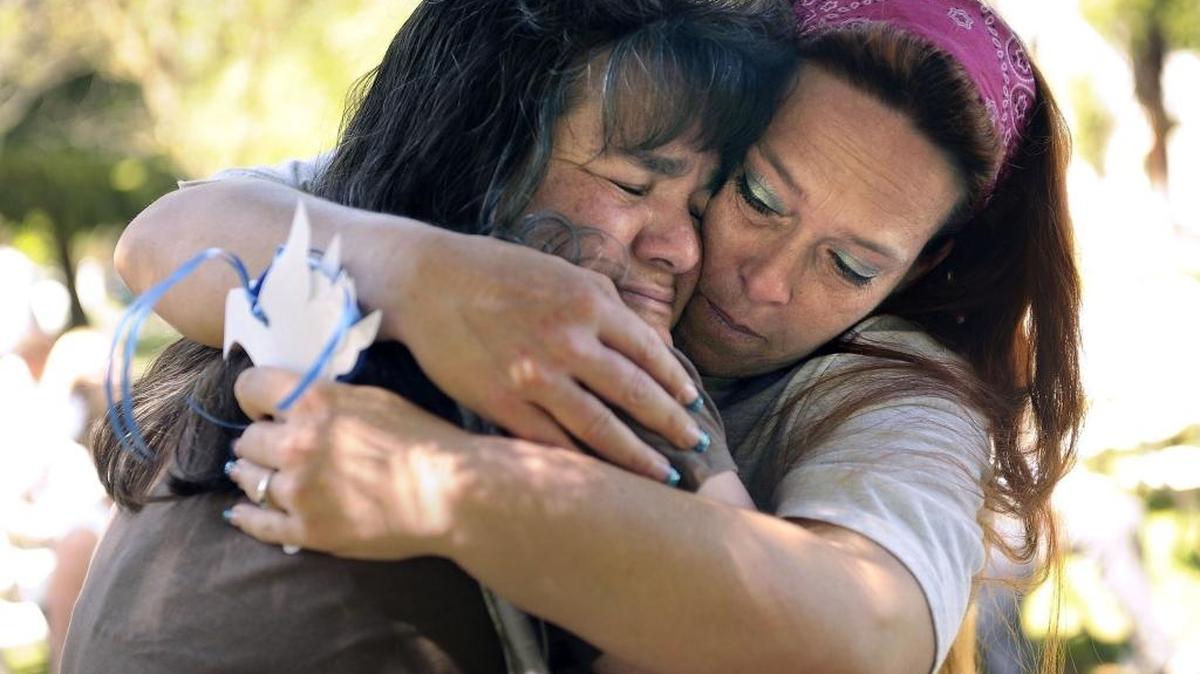 Diane Reis, left, mother of murder victims Matthew Fisher, 19, and Marcus Fisher, 21, is embraced by Desiree Parreira, mother of murder victim Samantha Parreira, 16, during a past National Crime Victims’ Rights Week ceremony in Merced.