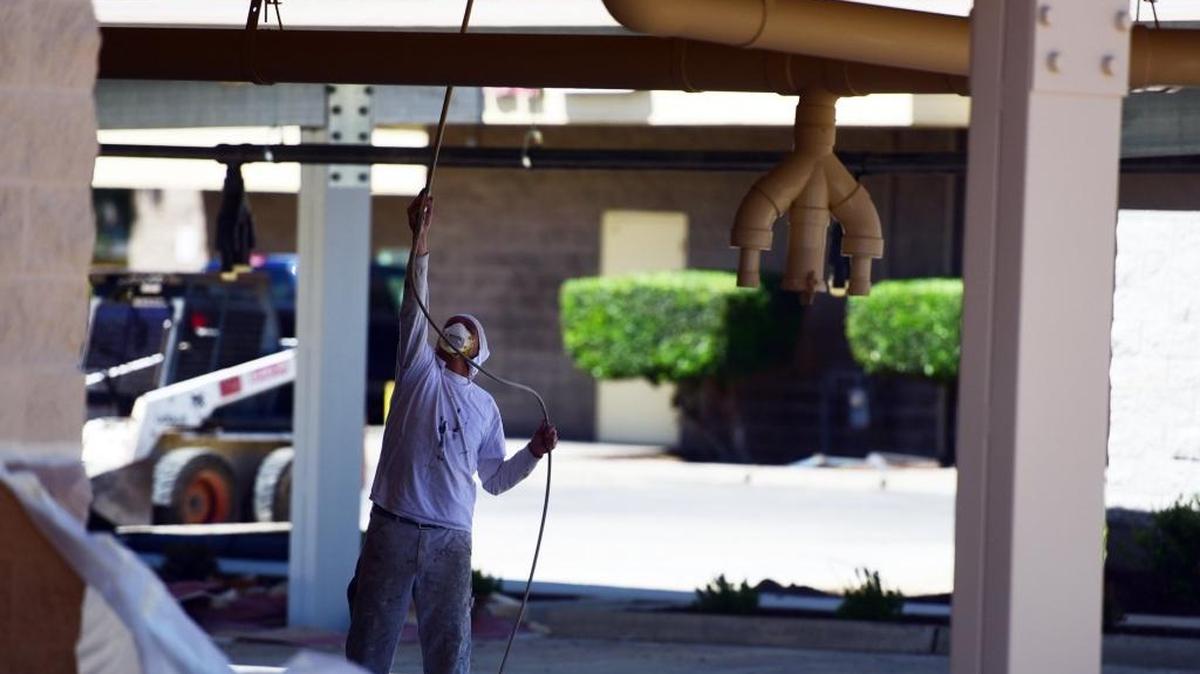 A worker paints the new Rapid Xpress Car Wash on G Street and Park Avenue in Merced on Monday, March 27, 2017. It's one of two car washes in the works in town.