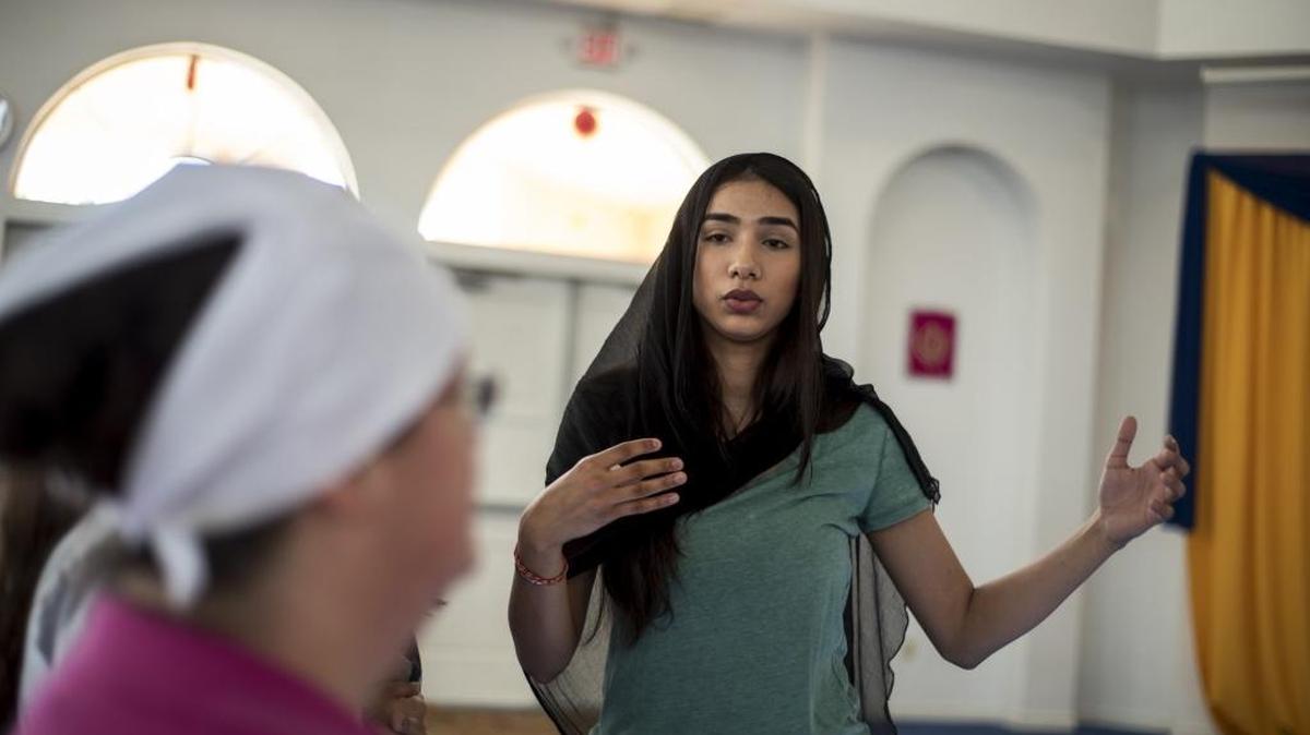 Gurpreet Sodhi, 18, of Livingston speaks to a nearby resident about the Sikh religion at the Sikh Temple Livingston on Saturday.