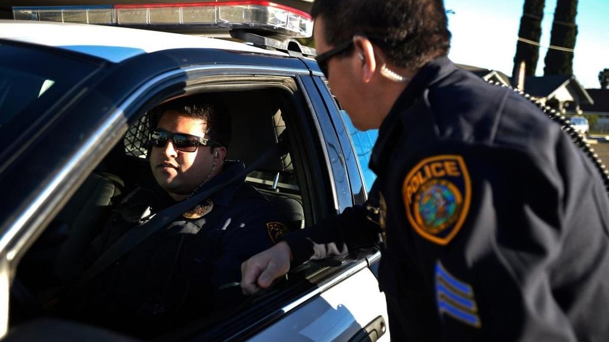 Livingston Police Sgt. Ray Fong, right, speaks with officer Wapinder Kang at the Livingston Police Department in Livingston, Calif., Wednesday, Dec. 31, 2014.