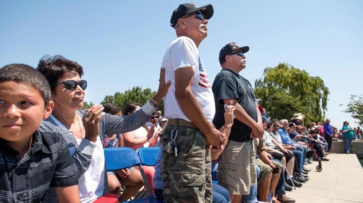 Esperanza Booke, left, puts her hand on her brother George A. Salinas, both of Corcoran, as veterans of the U.S. Marines stand during a Memorial Day Ceremony at San Joaquin National Cemetery on Santa Nella, Calif., on Sunday, May 29, 2016. Salinas’ brother Nacho Salinas is standing to his left.