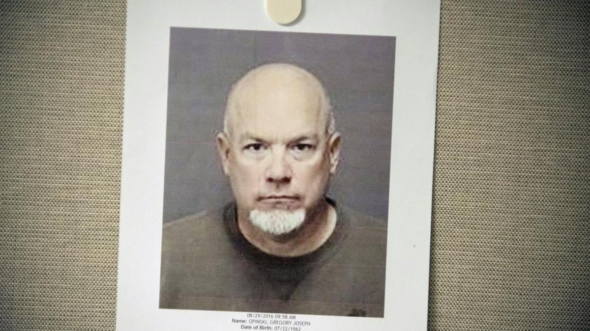 A booking photo of Greg Opinski hangs on Monday, Aug. 29, 2016, during a news conference at the district attorney's office in Merced.