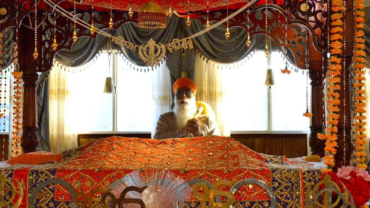 Bhai Gurmeet Singh Nimana, ceremonial leader at the Guru Nanak Sikh Mission in Livingston, stands over holy Scripture a few hours before a Diwali ceremony on Wednesday, Nov. 11, 2015.