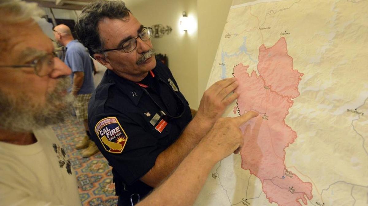 Mariposa County residents tab Merced Theatre review a map of the Detwiler Fire on Thursday, July 20, 2017, with John Bruno, a public information officer with the state Department of Forestry and Fire Protection.