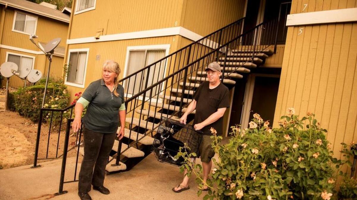 Jill Bollinger, 59, left, and Nick Bollinger, 37, right, load his cat into a vehicle after an evacuation was ordered for Mariposa residents due to the Detwiler fire in Mariposa, Calif., on Tuesday, July 18, 2017.