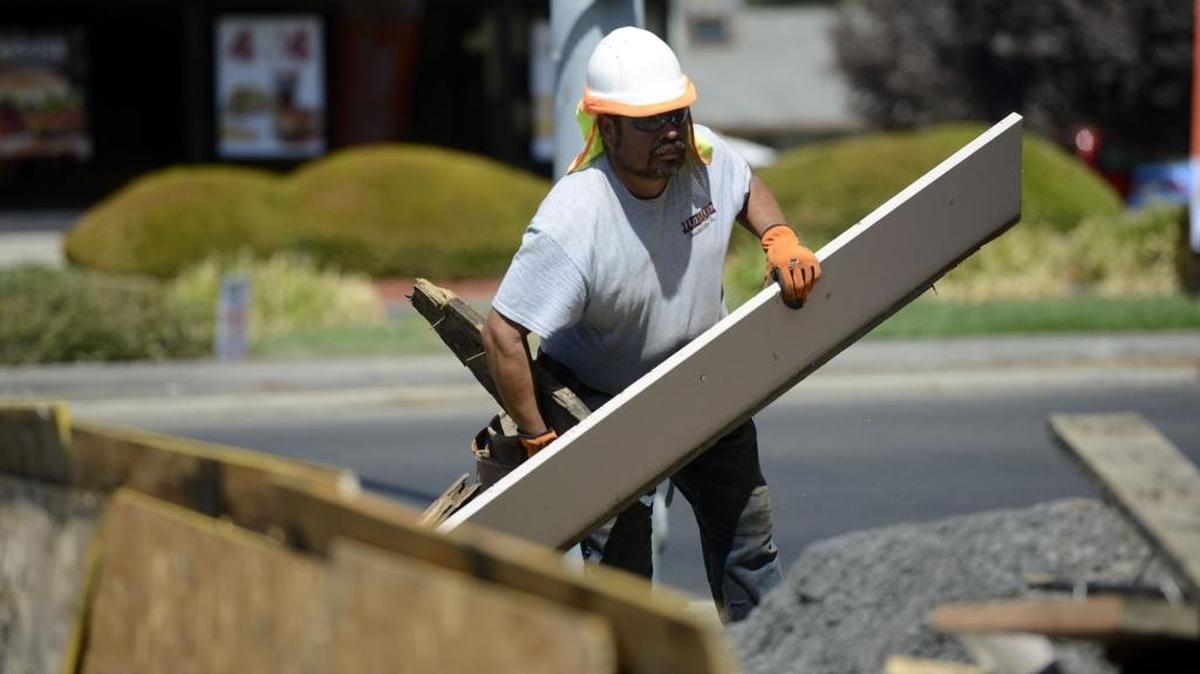 Mario Sanchez, 48, of Winton, clears debris near a construction site at Olive Avenue and M Street on Monday.