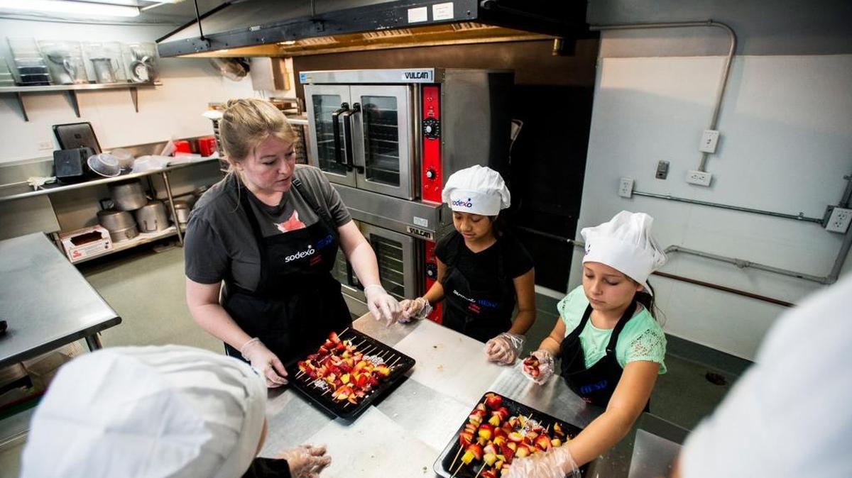 Merced resident Amanda Delerio, a teacher at Sheehy Elementary School, instructs children in the making of fruit skewers at Mitchell Senior Elementary School in Atwater, Calif., on Thursday, June 9, 2016. Government jobs, including teaching, rose by 1,000 in September compared with the same time last year, according to state numbers.