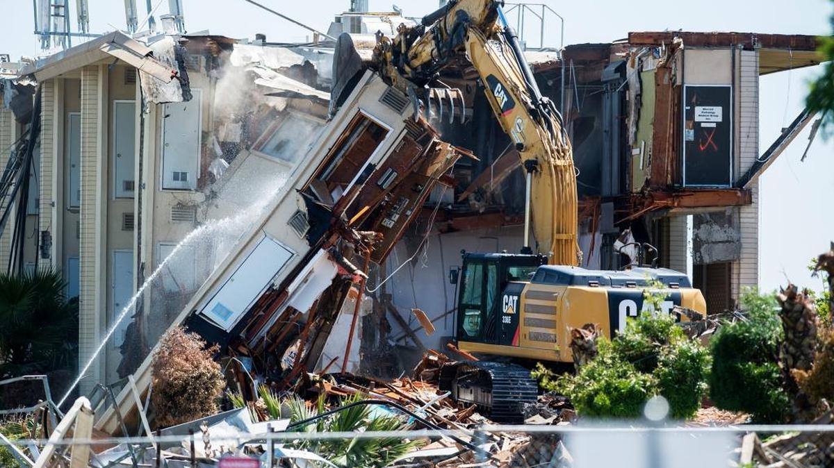 A demolition crew knocks down two vacant three-story buildings on Olive Avenue near M Street in Merced, Calif., on Friday, April 21, 2017. According to Merced city staff, a CVS Pharmacy and a Starbucks are expected to take over the location.