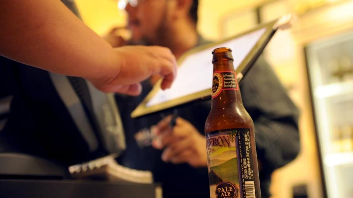 J&R Tacos co-owner Oscar Torres sells a beer to a customer at his downtown Merced restaurant Tuesday, May 21, 2013. The eatery is one of more than a dozen taking part in the Merced Art Hop Pub Crawl on Friday.