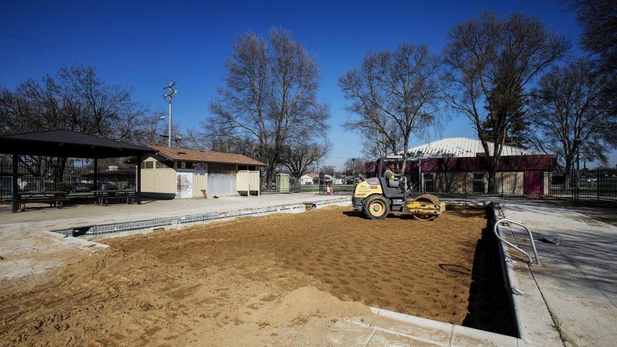 Jacob Taylor works Friday to fill a pool with dirt at Merced’s Stephen Leonard Park. A splash pad will replace the pool.
