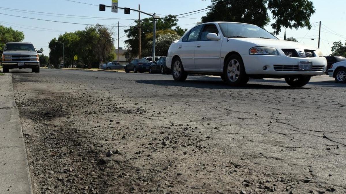 A car travels south on a busted up N Street near Golden Valley Health Center on Wednesday, Aug. 17, 2016.