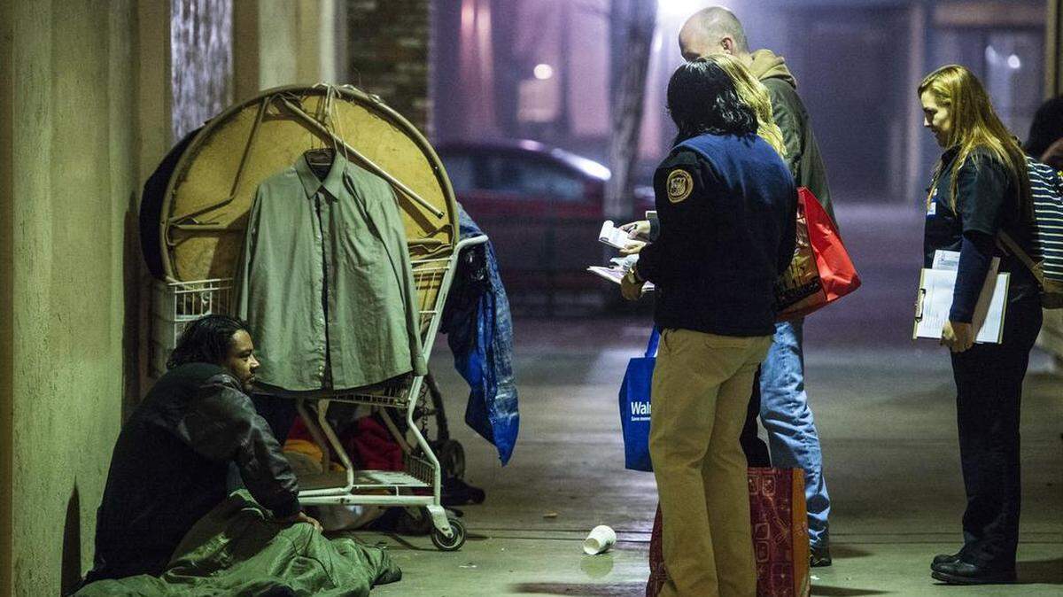 A group of Riggs ambulance service volunteers joined by Merced City Manager Steve Carrigan, stop to speak with a homeless man during the 2016 Merced City and County Continuum of Care Homeless Count in Merced, Calif., Thursday, Jan. 28, 2016. Approximately 150 volunteers walked the city to speak with the homeless and offer them a quarter gallon bag containing snacks, socks and various hygiene products.