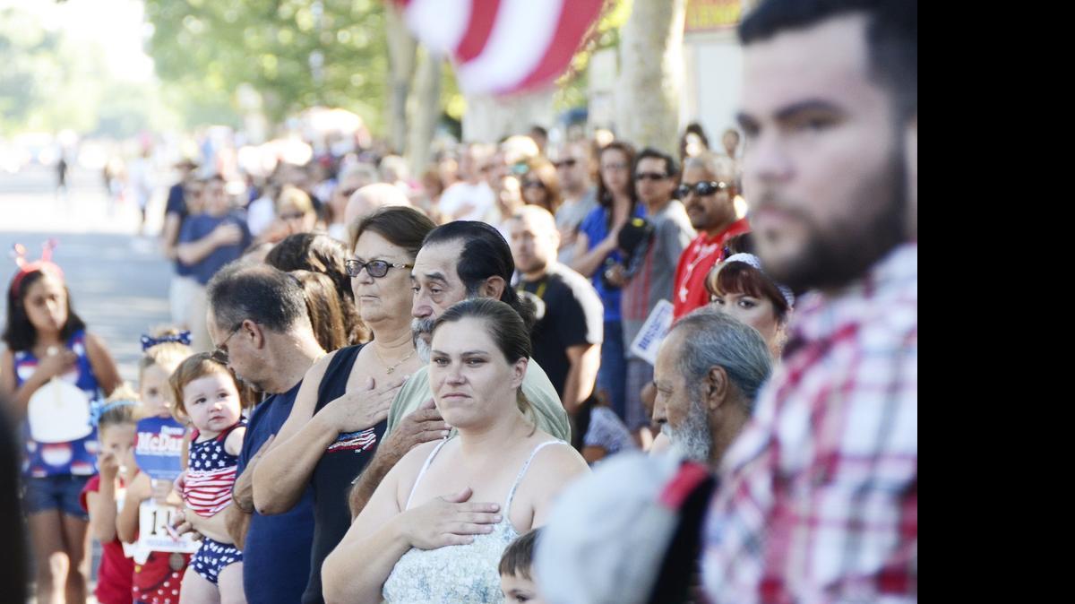 
Thousands of parade attendees place their hand over their hearts as the national anthem is sung at Ralston Park during the Atwater Fourth of July Parade last year.
