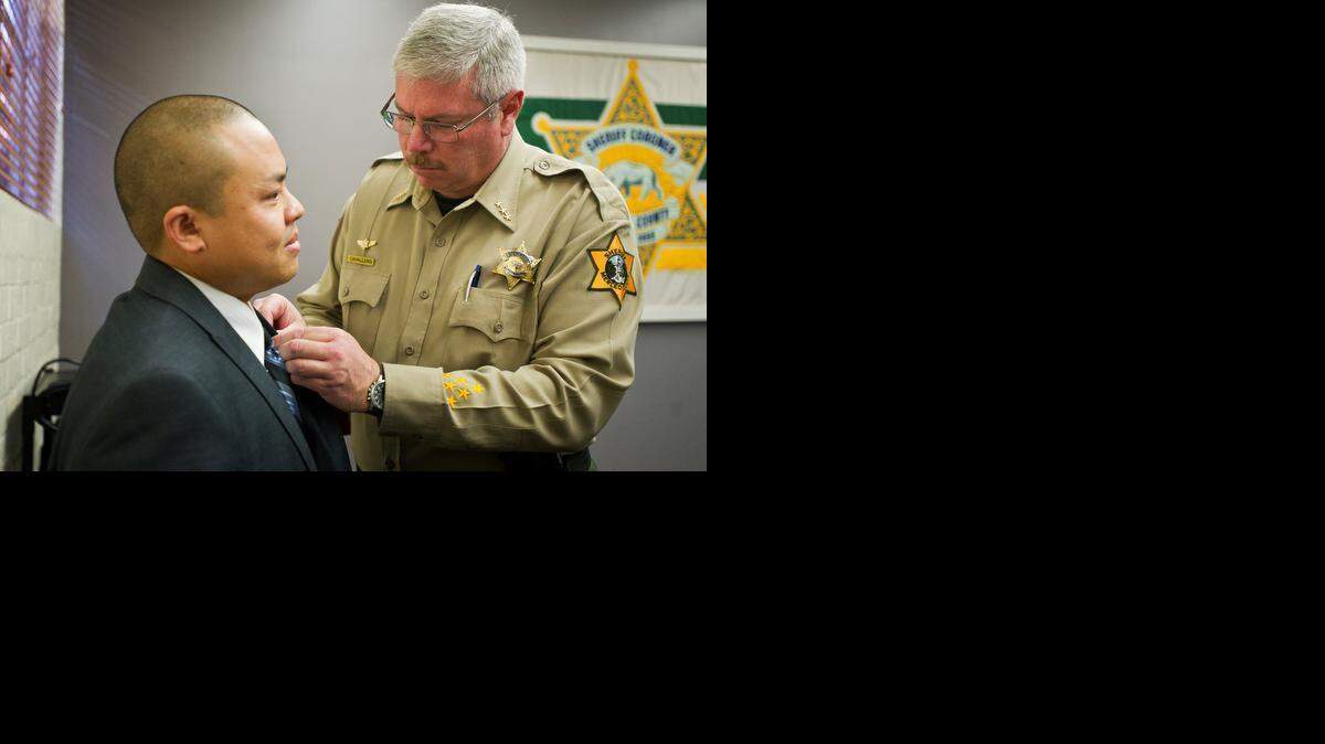 
Former Merced County Sheriff Tom Cavallero, right, pins a Lifesaving Medal on Merced resident Jeffrey Saechao, 33, at the Merced County Sheriff’s Department on  Monday. Saechao received the medal for pulling pilot Bryan Crantrell from his mangled helicopter after it crashed into a field in July 2014.
