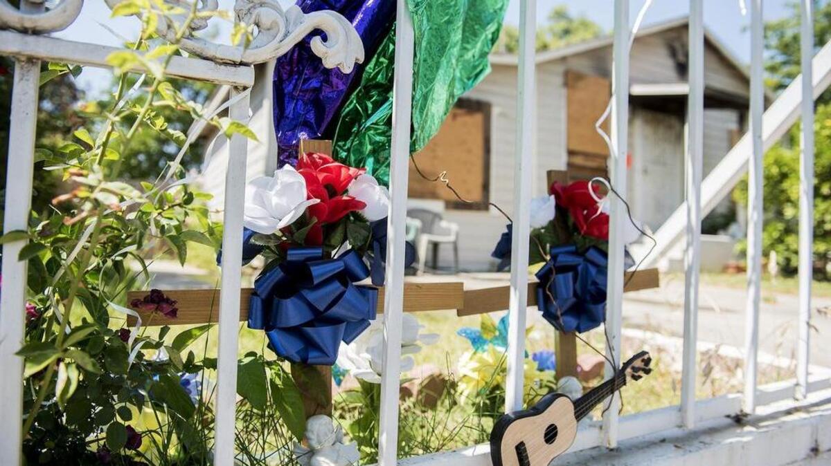 A memorial for a 2-year-old boy and a 5-year-old boy who died in an April house fire is seen outside the home at 954 W. 10th Street.