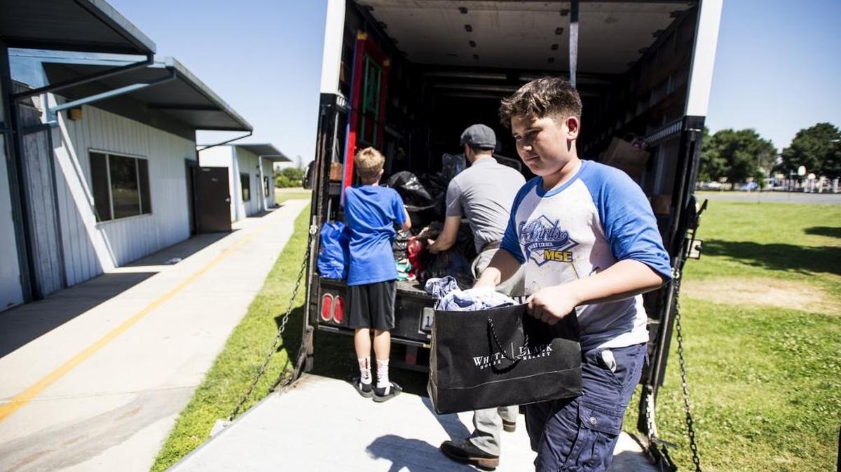 Mitchell Senior School student Nate Hillyer, 12, of Atwater, helps to unload donated items from an Atwater Elementary School District truck at Crookham Elementary School in Winton on Tuesday, May 31, 2016. The items were donated to displaced families after a fire destroyed the Schoolhouse Apartments complex across the street from the school on Friday, May 20, 2016.