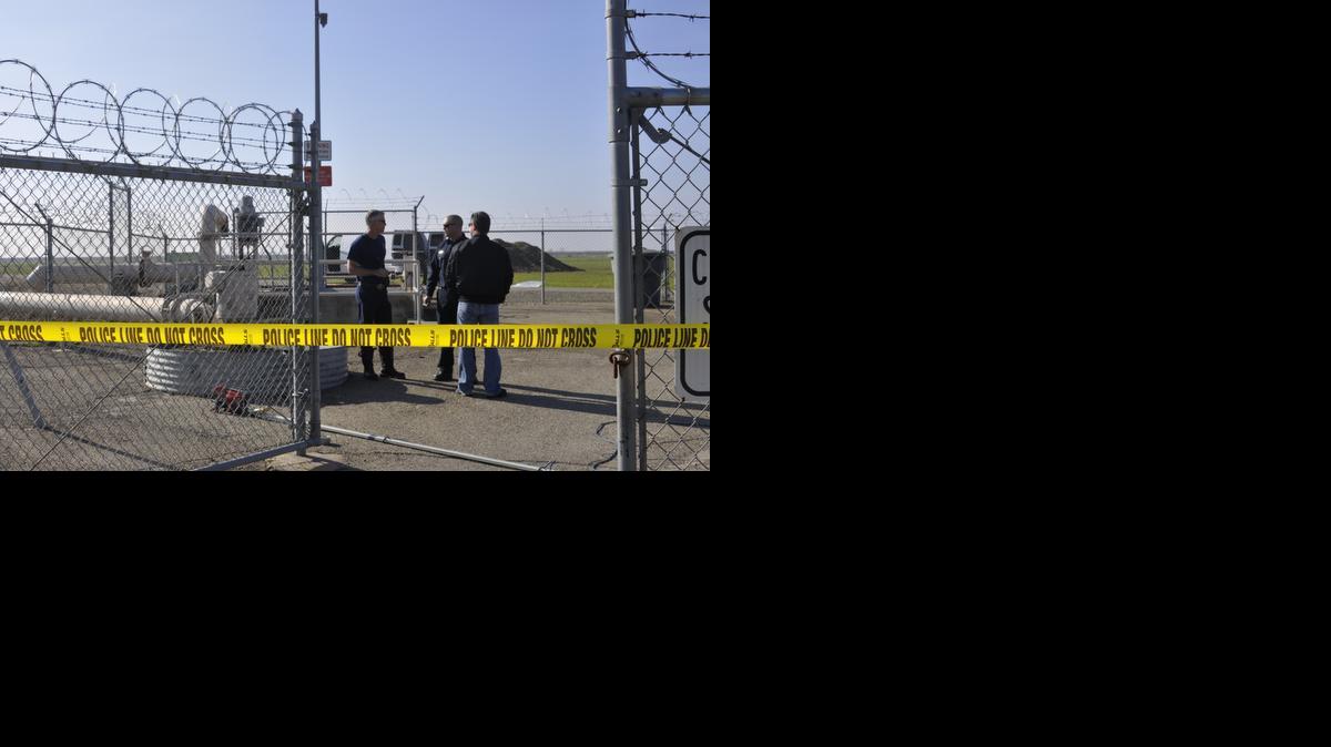 
Firefighters and law enforcement stand near a storm pump where the body of a man was found Monday in south Merced. 
