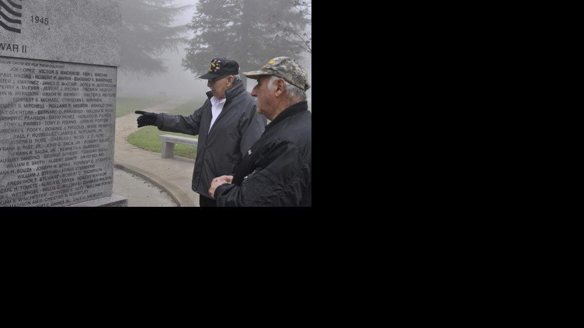 
Veterans Ralph Gonzales, left, and Larry Long look at the Merced County war memorial after vandals spray-painted it. Although volunteers cleaned up much of the paint, traces of the graffiti can still be seen. 
