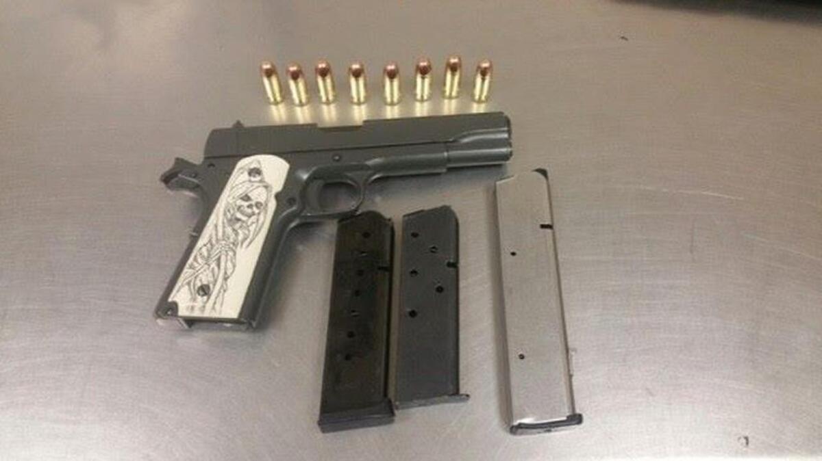 Officers found this .45-caliber handgun, seen here with ammunition, under the hood of a car.