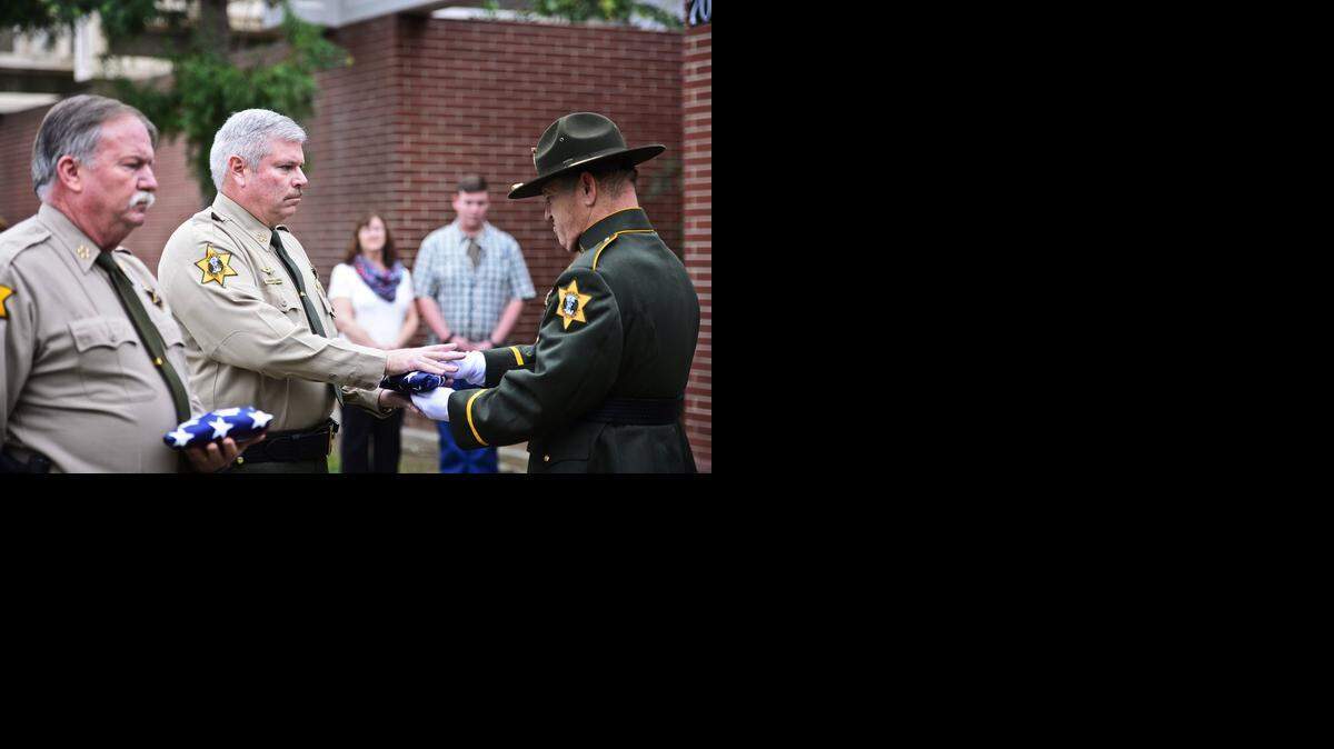 
Merced County Sheriff color guard member Sgt. Vince Gallagher, right, presents Merced County Sheriff Tom Cavallero with the American flag during a retirement ceremony in his honor at the Merced County Sheriff's Department located at 700 West 22nd Street in Merced, Calif., Wednesday, Dec. 24, 2014.
