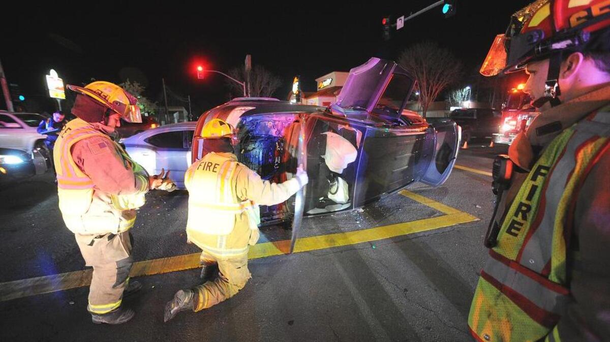 Los Banos firefighters disconnect the battery on a van involved in a DUI accident Saturday at the intersection of Fourth Street and East Pacheco Boulevard.