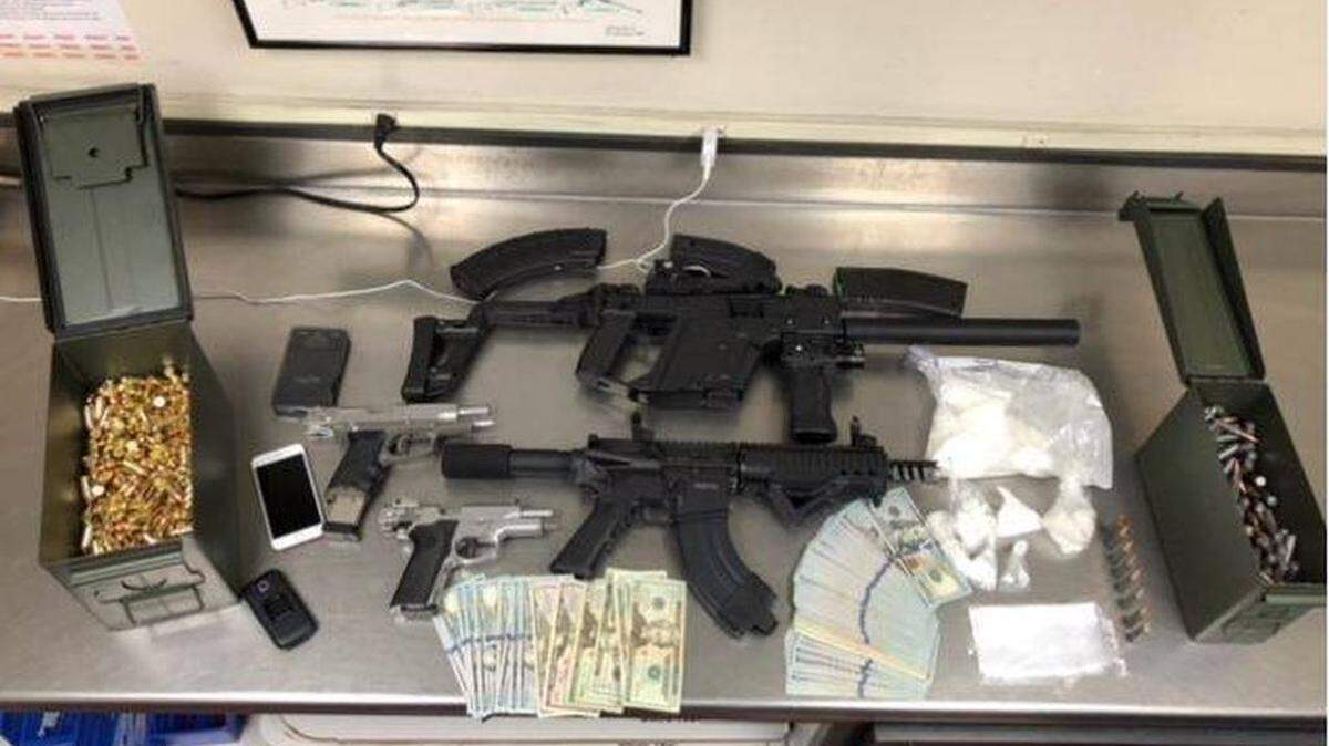 Officers say they found two handguns, an AR-15 pistol, a sub-machine gun, ammunition, a digital scale, more than a pound of cocaine, more than an ounce of methamphetamine and more than $12,000 in cash on Saturday, Jan. 6, 2018.