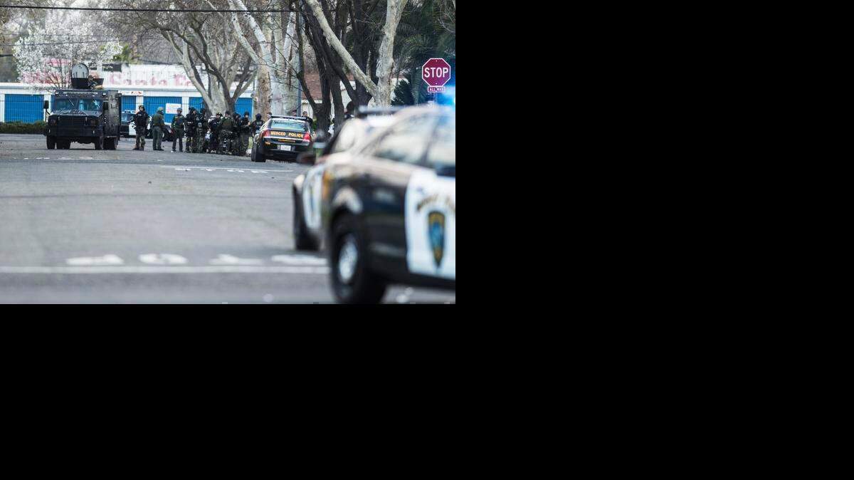 
The Merced Police S.W.A.T. moves into position near the intersection of I Street and West 23rd Street while searching for a suspect after a Merced Police officer was shot early Saturday morning near the intersection of West 22nd Street and H Street in Merced, Calif., Saturday, Feb. 28, 2015.
