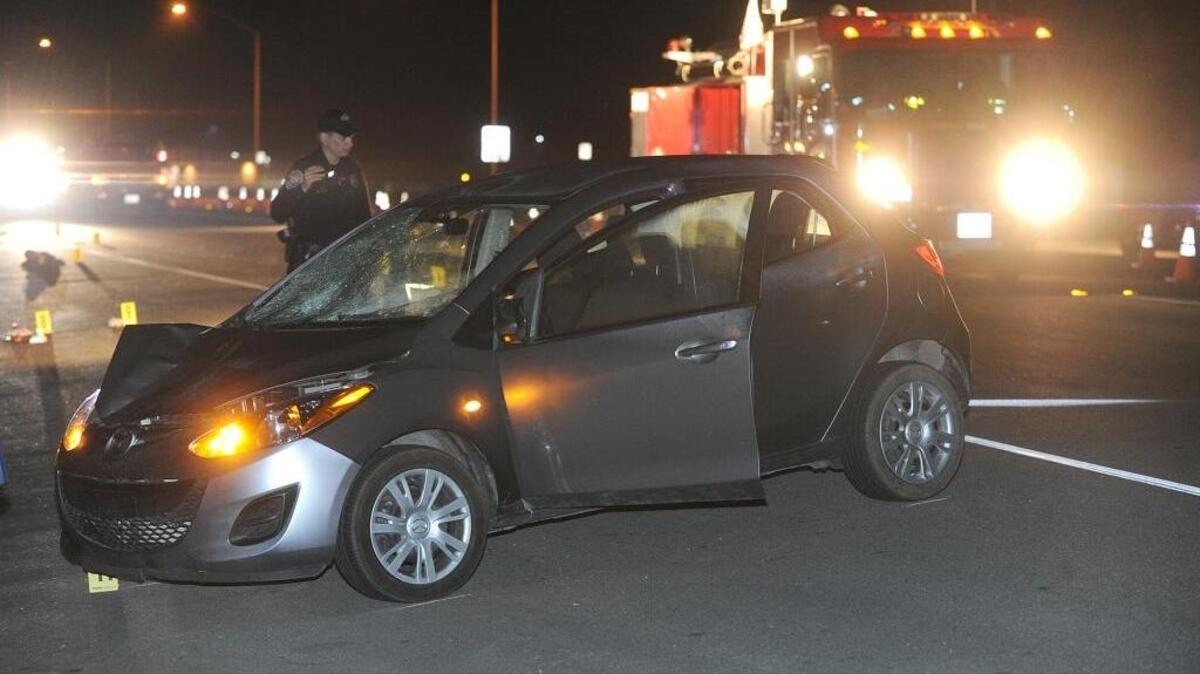 Los Banos police Officer Todd Pricolo looks over the car that stuck the pedestrian on Mercey Springs Road near Willmott Road on Wednesday, Feb. 10, 2016.