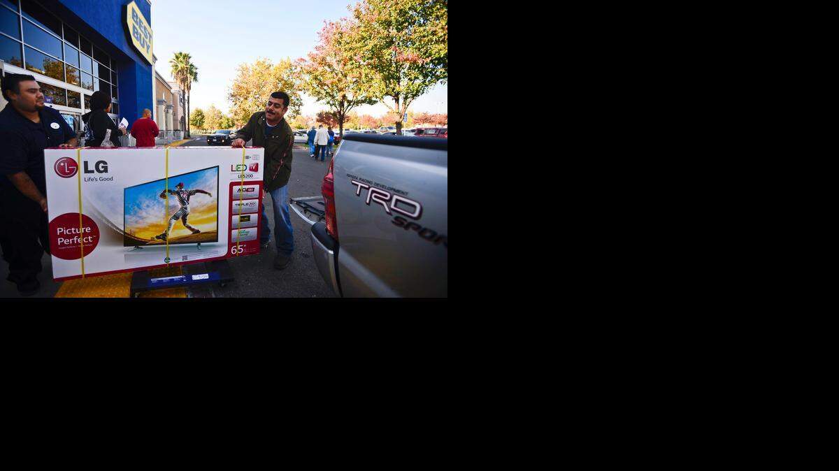
Atwater resident David Sanchez, 38, right, receives assistance Friday loading a television into his truck from Best Buy home theater sales associate Arthur Guerro at the store on West Olive Avenue in Merced.
