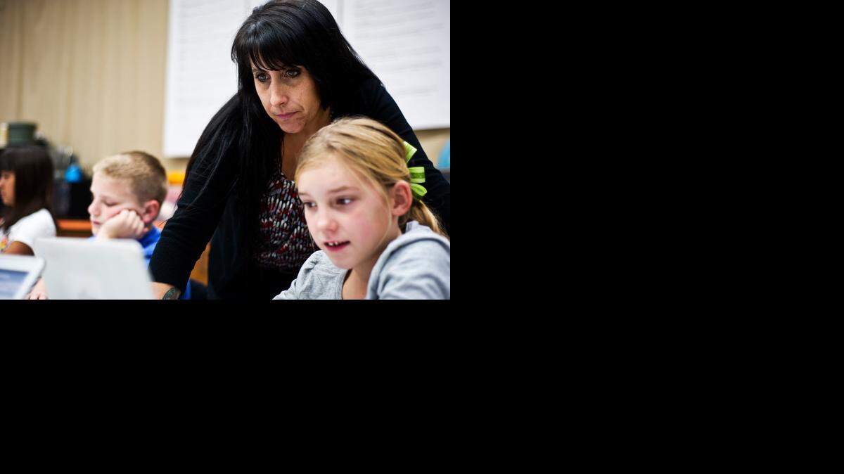 
Ballico Elementary School teacher Joanna Conrado, 44, of Ballico works with fifth-grader Angel Thompson, 10, on a computer program exercise about the human nervous system at Ballico Elementary School on Tuesday, Jan. 13, 2015. Conrado was named the “e-Learning Educator of the Year” by Computer-Using Educators.

