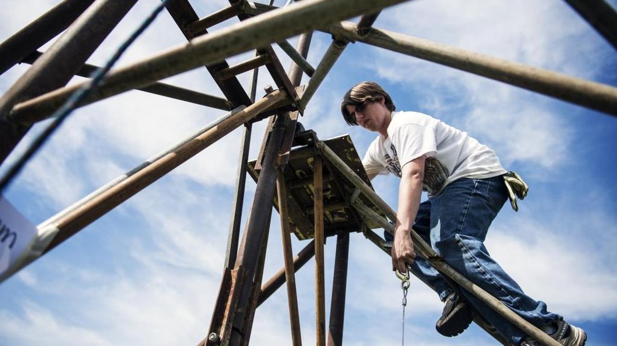 Cody Regalado, 22, of Los Banos climbs atop his team’s catapult in preparation for launching a payload Wednesday during the Physics 4A Siege Weapons Competition at Merced College.