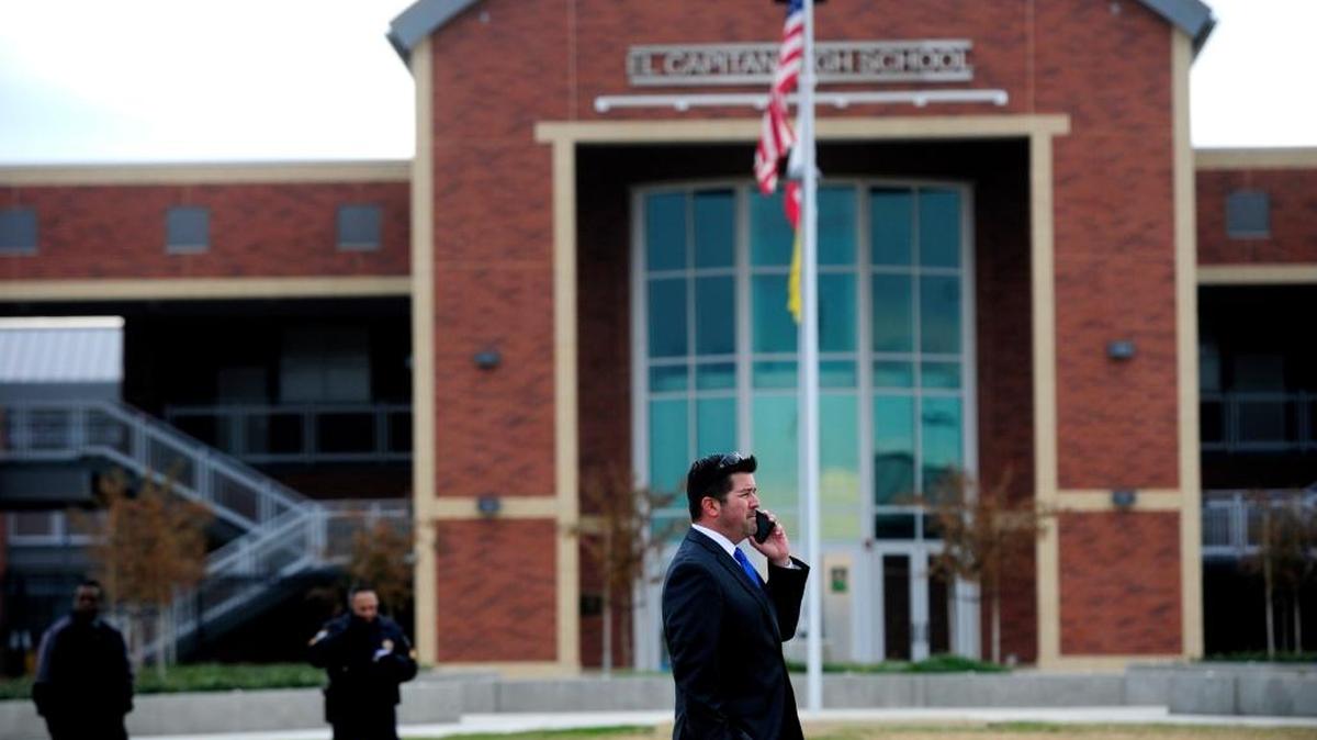 Merced Union High School District official Costa Aguilar monitors the scene as school staff and students evacuated the campus due to a bomb threat on Dec. 3, 2015, in Merced.